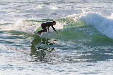 Image showing Long boarder surfing the waves at sunset