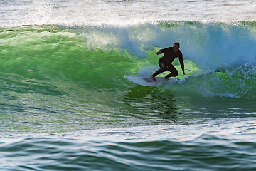 Image showing Long boarder surfing the waves at sunset