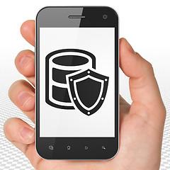 Image showing Programming concept: Hand Holding Smartphone with Database With Shield on display