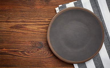 Image showing napkin and dark plate on wooden table