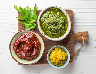 Image showing various sauces on wooden cutting board