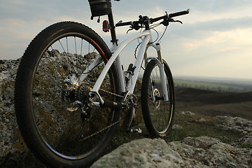 Image showing Bicycle stands on a rock