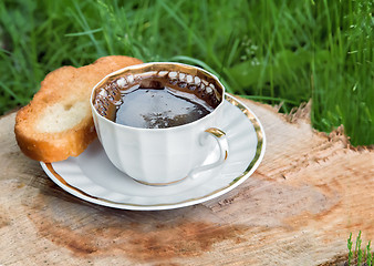 Image showing Still life: a Cup of black coffee in the garden.