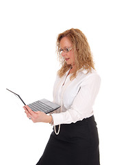 Image showing Business woman standing and working with laptop.