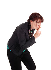 Image showing Middle age woman with finger over mouth.