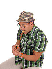 Image showing Hispanic man lightning his cigar.