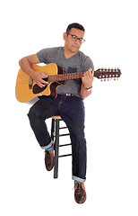 Image showing Middle age man playing his guitar.