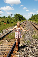 Image showing Young woman standing on railroad truck's.