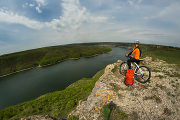 Image showing Cyclist in Orange Wear Riding the Bike Down Rocky Hill