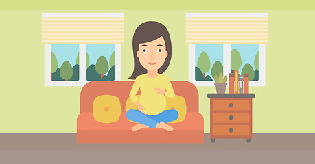 Image showing Pregnant woman sitting on sofa.