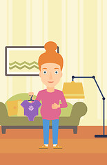 Image showing Pregnant woman with clothes for baby.