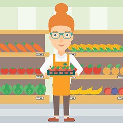 Image showing Supermarket worker with box full of apples.