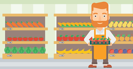 Image showing Supermarket worker with box full of apples.