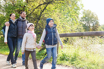 Image showing happy family with backpacks hiking in woods