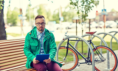 Image showing sad young hipster man with tablet pc and bike