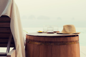 Image showing glasses of water with hat on barrel at hotel beach