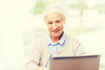 Image showing happy senior woman with laptop at home