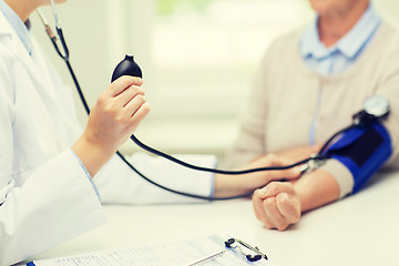 Image showing doctor with tonometer and senior woman at hospital