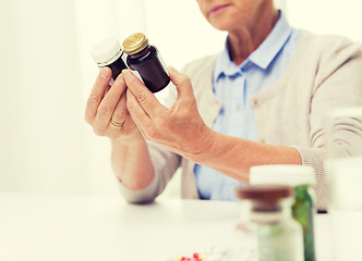 Image showing close up of senior woman with medicine jars