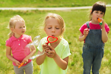 Image showing group of kids blowing soap bubbles outdoors