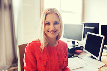 Image showing happy creative female office worker with computers