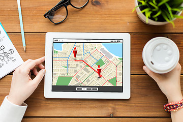 Image showing close up of woman with tablet pc on wooden table