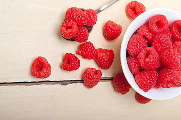 Image showing bunch of fresh raspberry on a bowl and white table