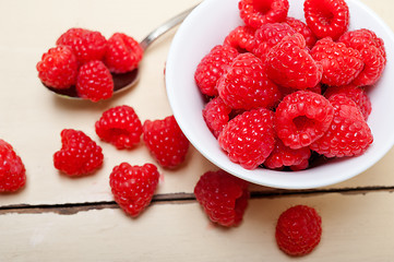 Image showing bunch of fresh raspberry on a bowl and white table