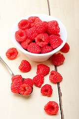 Image showing bunch of fresh raspberry on a bowl and white table