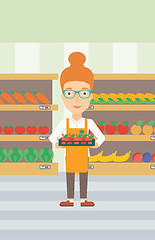 Image showing Supermarket worker with box full of apples.