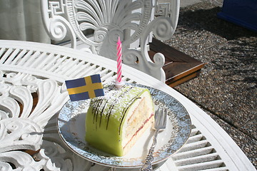 Image showing Pastry with marzipan, flag and candle on top