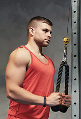 Image showing man flexing muscles on cable machine gym