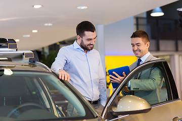 Image showing happy man with car dealer in auto show or salon