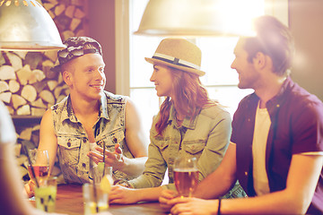 Image showing happy friends drinking beer and cocktails at bar