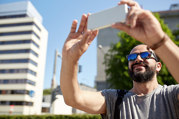 Image showing man taking video or selfie by smartphone in city