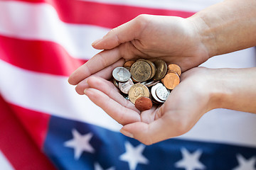 Image showing close up of hands with coins over american flag