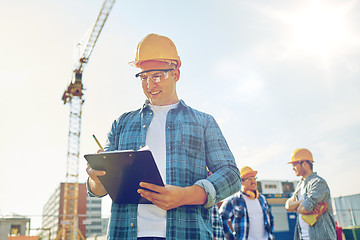 Image showing builder in hardhat with clipboard at construction