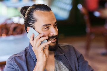 Image showing happy man calling on smartphone at bar or pub