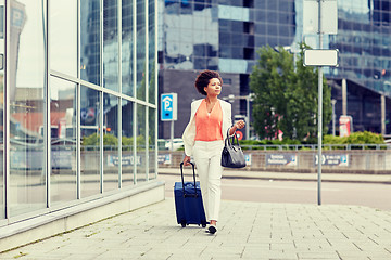 Image showing young african woman with travel bag in city