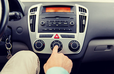 Image showing close up of male hand using climate control in car