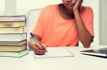 Image showing close up of woman with laptop and books at home