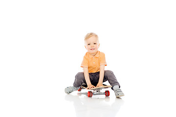 Image showing happy little boy sitting on skateboard