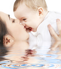 Image showing happy mother kissing baby boy in water