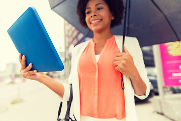 Image showing close up of woman with umbrella and tablet pc