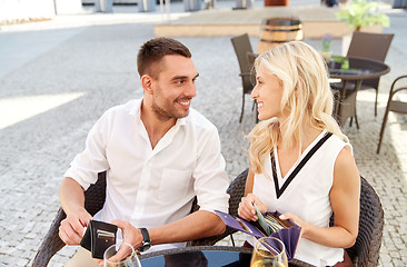 Image showing happy couple with wallet paying bill at restaurant