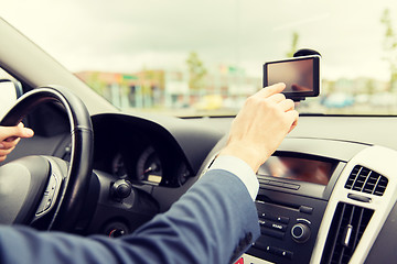 Image showing close up of man with gps navigator driving car