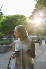 Image showing the woman with the phone drinking coffee in the Park