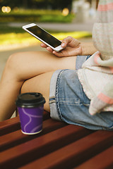 Image showing woman drinking coffee and looking at phone