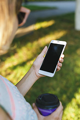 Image showing woman drinking coffee and looking at phone