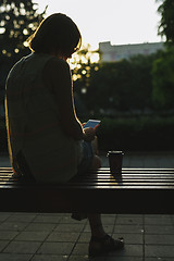 Image showing woman drinking coffee and looking at phone
